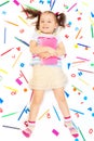 Girl holding pink book laying among stationery