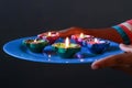 A girl holding a plate of diyas to clebrate diwali Royalty Free Stock Photo