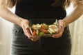 Woman holding a plate of salad in hands