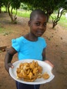 Girl holding plateful of wild mushrooms.