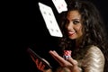 Girl holding poker chips and tablet, black background