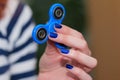 A girl is holding a popular toy fidget spinner in her hands. Stress relief. Anti stress and relaxation fidgets, spinner for tired.