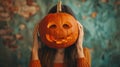 Girl holding a pumpkin for Halloween in front of her head Royalty Free Stock Photo