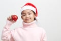 Girl holding a red christmas ball in sweater and santa hat Royalty Free Stock Photo