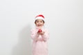 Girl holding a red christmas ball in sweater and santa hat Royalty Free Stock Photo