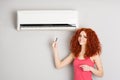 Girl holding a remote control air conditioner Royalty Free Stock Photo