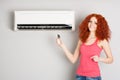 Girl holding a remote control air conditioner Royalty Free Stock Photo