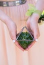 Girl holding a small florarium with succulent and wedding rings inside