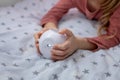 The girl is holding a small multimedia projector in her hands.