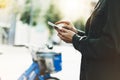 Girl holding smart phone on background sun atmospheric city and bike, hipster using in female hands and texting mobile Royalty Free Stock Photo