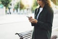 Girl holding smart phone on background sun atmospheric city and bike, hipster using in female hands and texting mobile Royalty Free Stock Photo