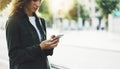 Girl holding smart phone on background sun atmospheric city and bike, hipster using in female hands and texting mobile, street Royalty Free Stock Photo