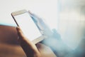 Girl holding smartphone with white empty screen in night atmospheric city.Closeup on blurred background.