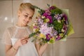 Girl holding a spring bouquet of tender green, purple and violet flowers decorated with bush branches Royalty Free Stock Photo