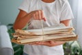 The girl is holding a stack of newspapers in her hands. Ecology. The child hands over paper for waste paper