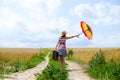 Girl holding suitcase and umbrella standing on Royalty Free Stock Photo