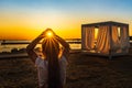 Girl holding sun in her hands witch trough shines Sunstar with sunrays, at sunset on beach Royalty Free Stock Photo