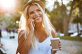 Girl holding take away coffee cup and talking on smartphone Royalty Free Stock Photo