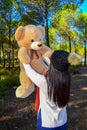 Girl holding a teddy bear on the Forest Landscape