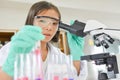 Girl holding test tube and using microscope scientific experiment i Royalty Free Stock Photo