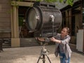 The girl is holding on to a large movie projector with her hands