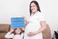 Girl holding a 30 weeks sign to her expectant mother Royalty Free Stock Photo