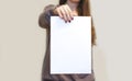 Girl holding white A4 blank paper vertically. Leaflet presentation. Pamphlet hold hands. Woman show clear offset paper. Sheet