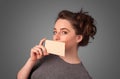 Girl holding white card at front of her lips with copy spac Royalty Free Stock Photo