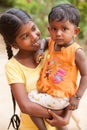 Girl holding a younger sister in her arms