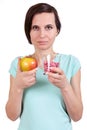 The girl holds apple and vitamins in hand