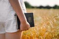 Girl holds bible in her hands. Reading the Holy Bible in a field. Concept for faith, spirituality and religion Royalty Free Stock Photo