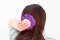 A girl holds a blue ice bag near her head to eliminate pain in the head, lowering blood pressure in case of arterial