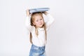 A girl holds books on her head. Isolated over white background Royalty Free Stock Photo