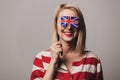 Girl holds British flag on gray background Royalty Free Stock Photo