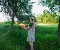 Girl holds a burning book in her hands. A young woman in a forest burns a book