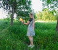 Girl holds a burning book in her hands. A young woman in a forest burns a book