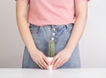 The girl holds a cactus against the background of the pubic zone of the urological and reproductive system. Concept of