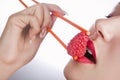 Girl holds chopsticks a raspberry Royalty Free Stock Photo