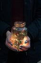 Girl holds christmas lights in glass jar Royalty Free Stock Photo