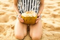 Girl holds coconut in hand