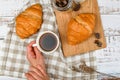 Girl holds a coffee mug. on the background of a croissant. coffee with a croissant. the beginning of the morning. Coffee cup. Top