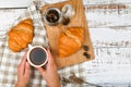 Girl holds a coffee mug. on the background of a croissant. coffee with a croissant. the beginning of the morning. Coffee cup. Top