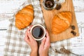 Girl holds a coffee mug. on the background of a croissant. coffee with a croissant. the beginning of the morning. Coffee cup. Top