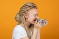 Girl holds crumpled money and wants to eat it, playful mood, unusual hairstyle, white dreadlocks