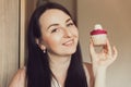 The girl holds delicious cupcake with white cream in her hands, decorated balls with coconut powder. Holds cupcake close to her Royalty Free Stock Photo