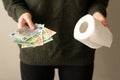 Girl holds euro banknotes and toilet roll. close-up