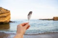 Girl holds a feather of a bird in the background of the sea. Beautiful sunset. Close-up Royalty Free Stock Photo