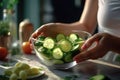 a girl holds a glass bowl with cucumber slices in her hands in a bright kitchen. close up view, Generative AI