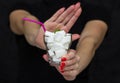 Girl holds a glass filled with cubes of white sugar, rejects the use of sugar