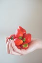 Girl holds a handful of fresh pure strawberries in her palms.